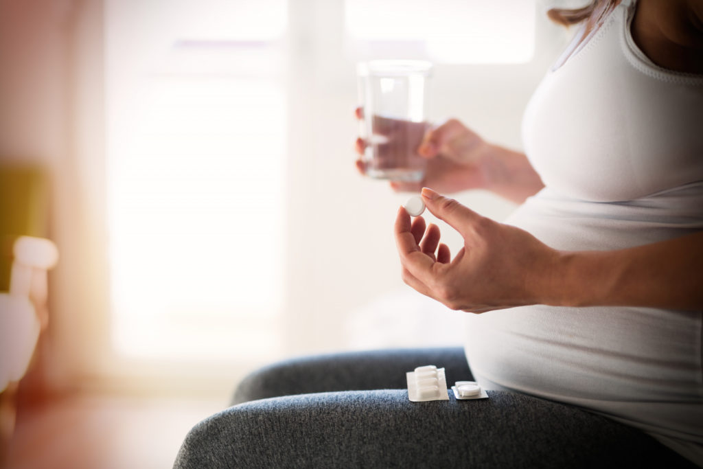 A pregnant woman is taking anti-heartburn pills.