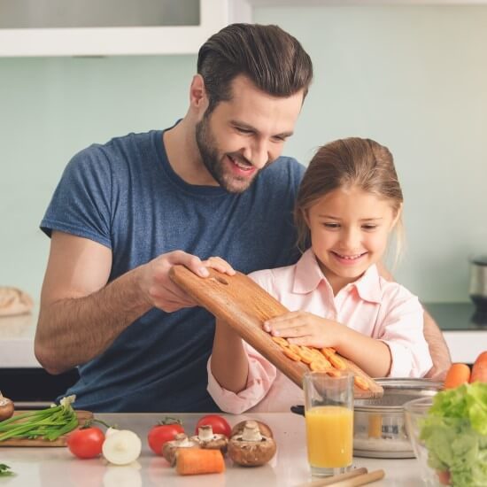 A young father and his daughter are preparing lunch together.