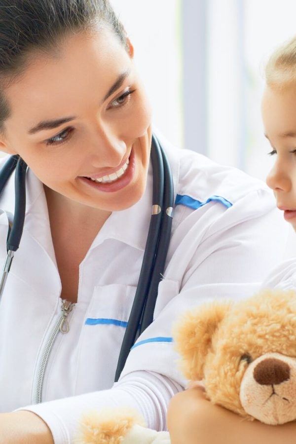 A little girl with a teddy is at the doctor’s.