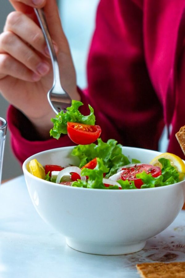 An employee is having lunch at his workplace – a salad and crackers.