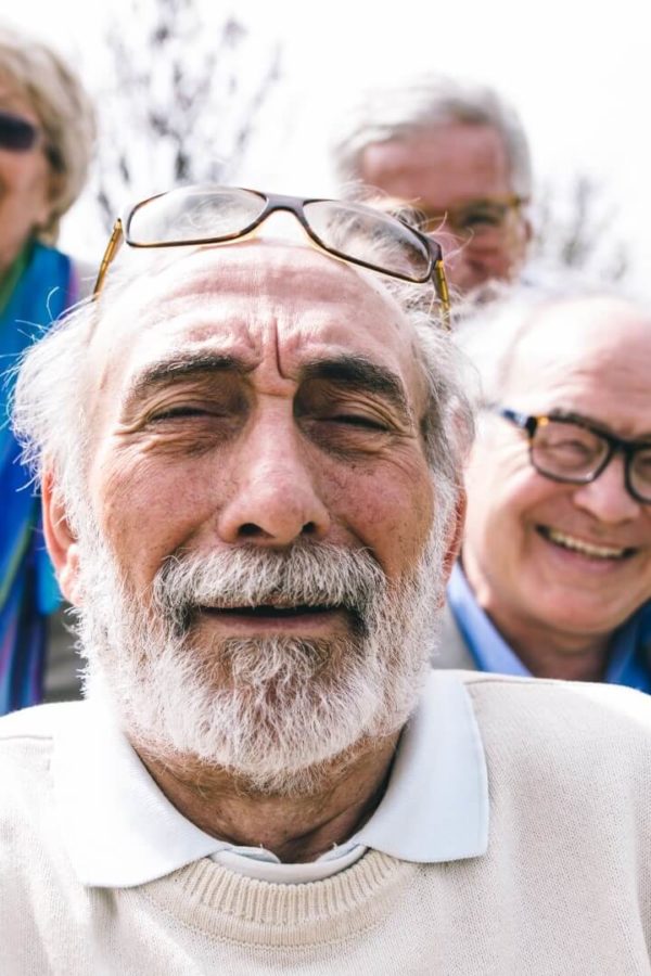 A group of elderly people are looking at the camera to take a picture.