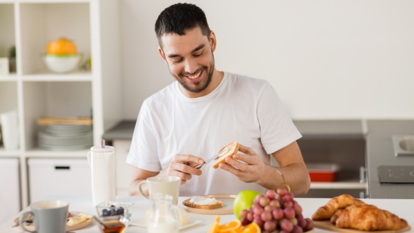 The man laughs while preparing a healthy breakfast.