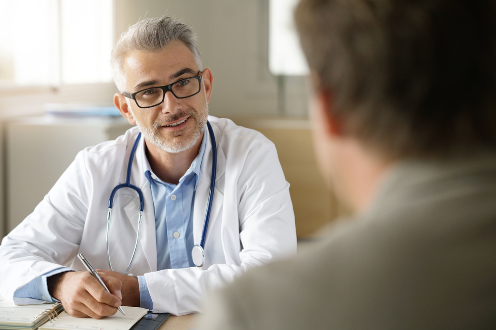 A doctor is talking to a patient in the office.