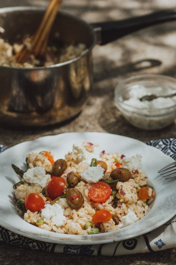 Rice salad with asparagus on a ceramic plate.