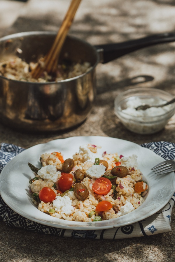 Rice salad with asparagus on a ceramic plate.