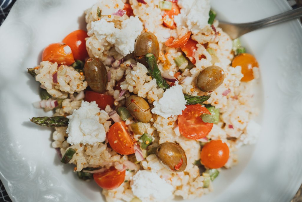 Rice salad with asparagus on a ceramic plate.