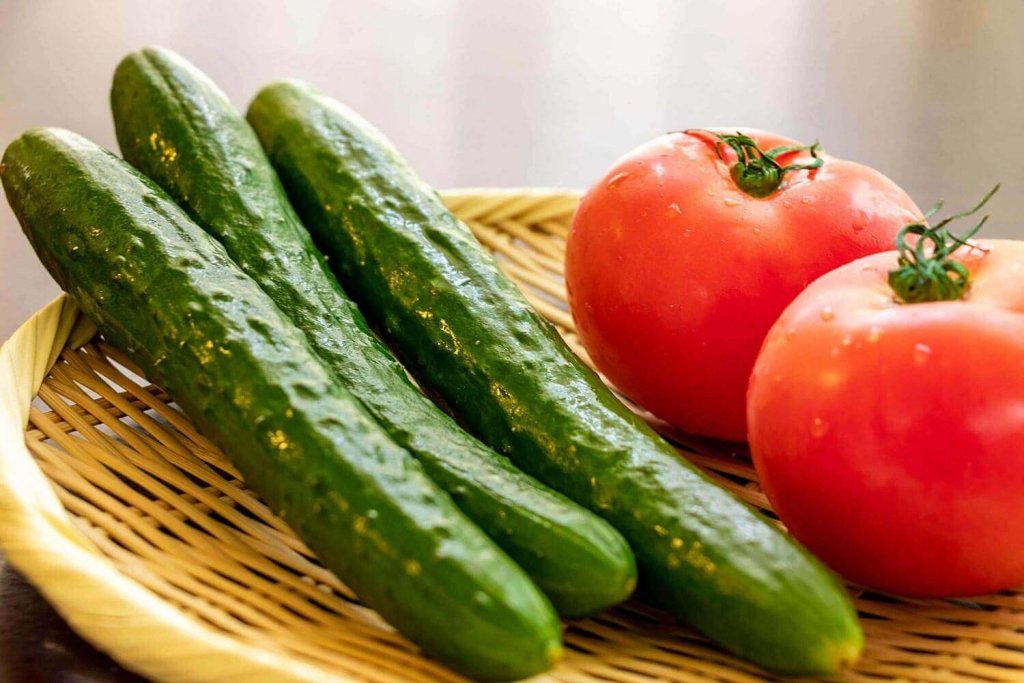 Tomatoes and cucumbers on a wooden background.