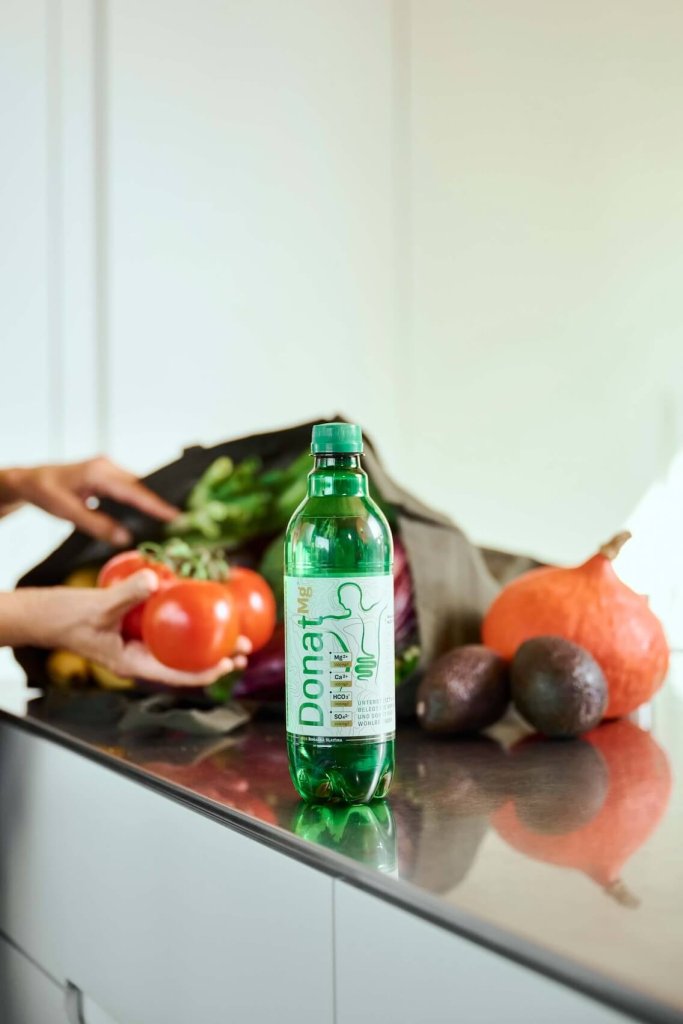  Eine Flasche natürliches Mineralwasser Donat Mg auf dem Tisch. Donat Mg reguliert die Verdauung auf natürliche Weise und beseitigt Verstopfung.